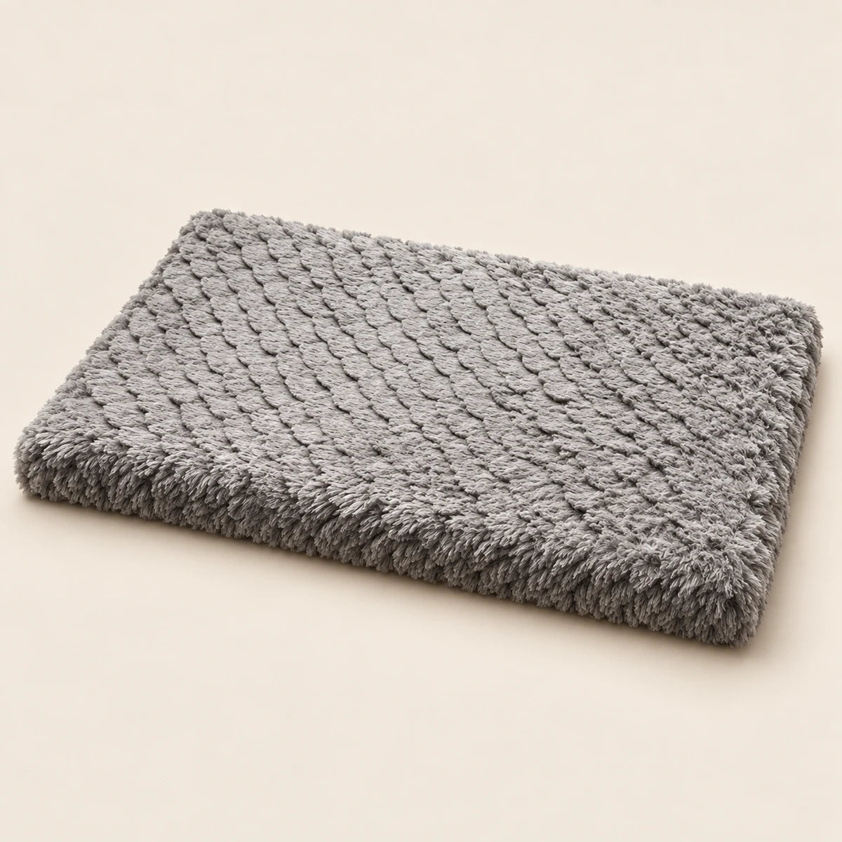 Flat rectangular grey plush dog mat on a sand-coloured background